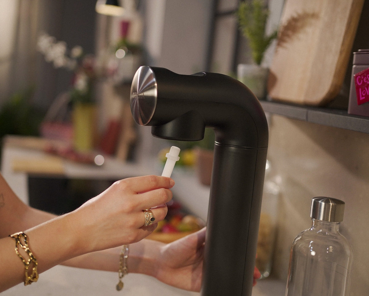 Inserting nozzle in black sodaONE water sparkler